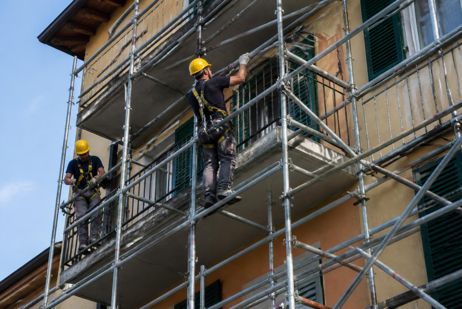 Operai che montano un ponteggio sulla facciata di un edificio